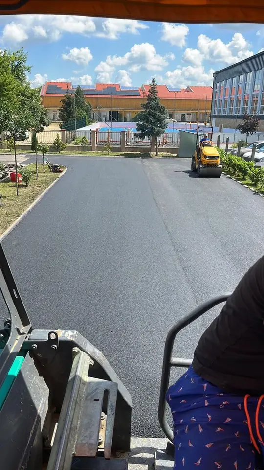 Kilátás a finisherről: intézményi udvar és sportpálya melletti terület aszfaltozása, hengerrel