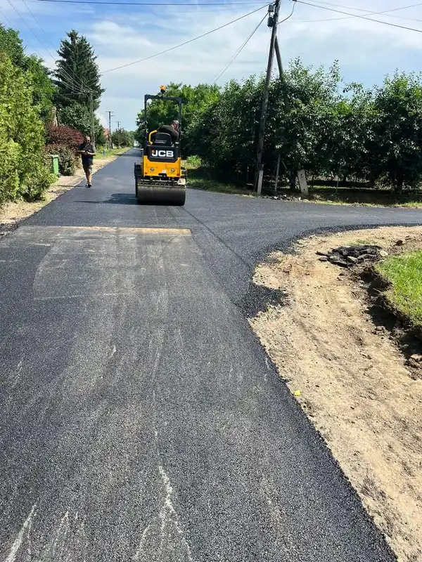 JCB úthenger tömöríti az új aszfaltot egy utcai csatlakozásnál